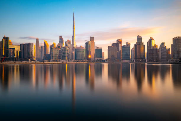 Skyscrapers reflected in water at sunrise in Dubai, highlighting the UAE's modern business environment.