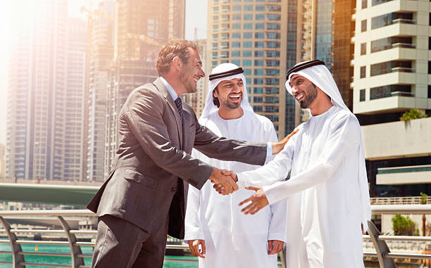 Businessmen shaking hands in Dubai, symbolizing successful business opportunities in a thriving cityscape.