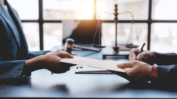 Two business professionals exchange documents in an office, symbolizing IFZA Free Zone license promotions.